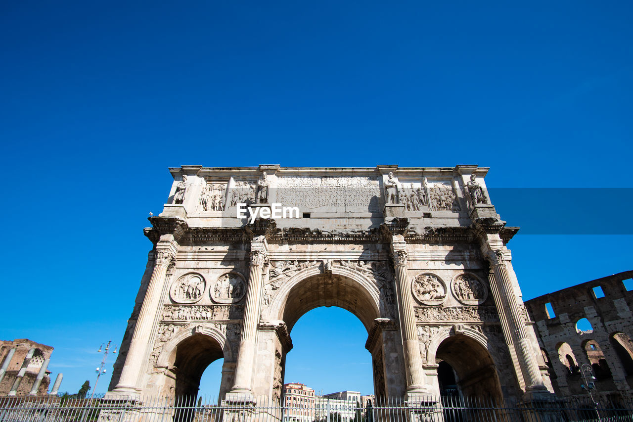architecture, landmark, travel destinations, arch, history, the past, built structure, blue, sky, city, clear sky, monument, travel, triumphal arch, tourism, nature, memorial, building exterior, sunny, ancient history, low angle view, day, outdoors, copy space, ancient, no people