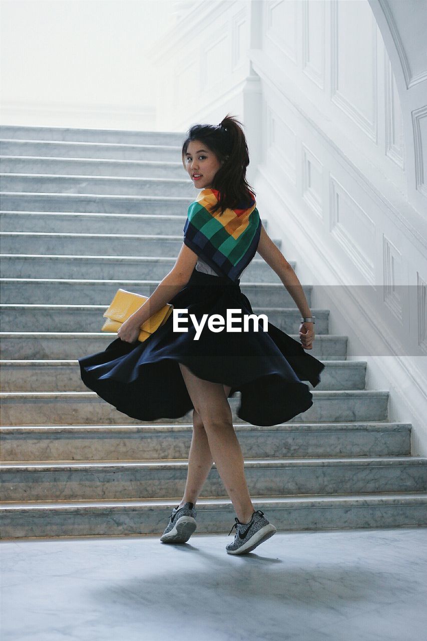 Portrait of beautiful young woman by stairs