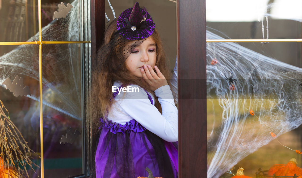 Cute girl in costume standing by door