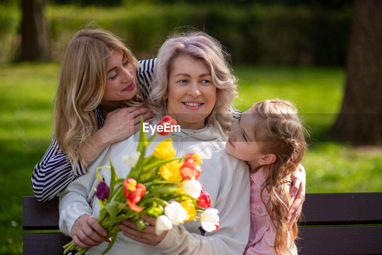 portrait of smiling friends with roses