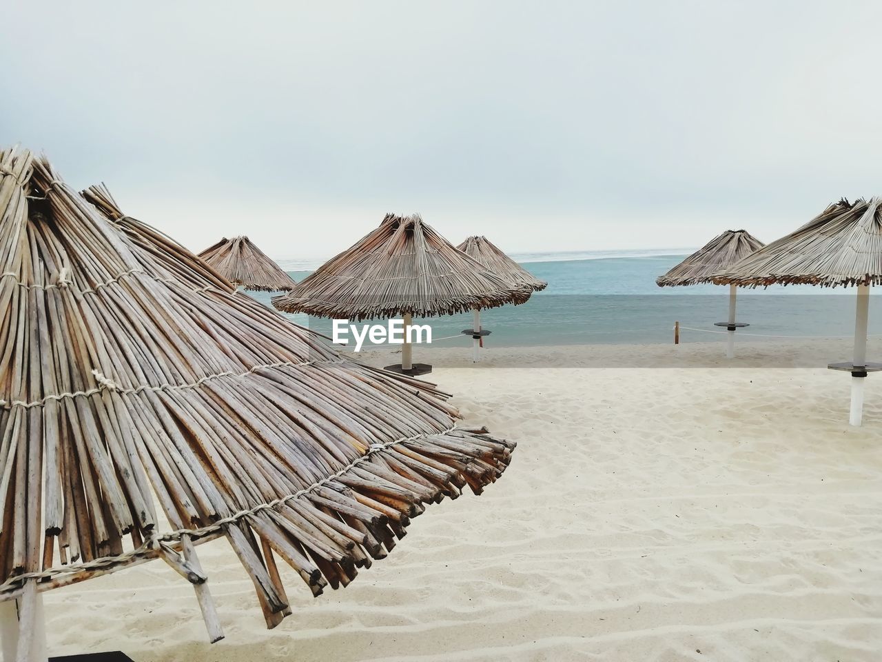 Panoramic view of lounge chairs on beach against sky