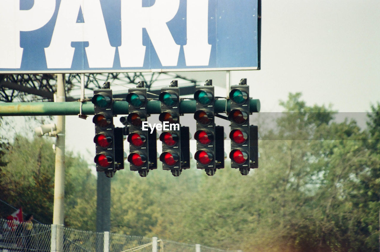 Low angle view of road signal by billboard