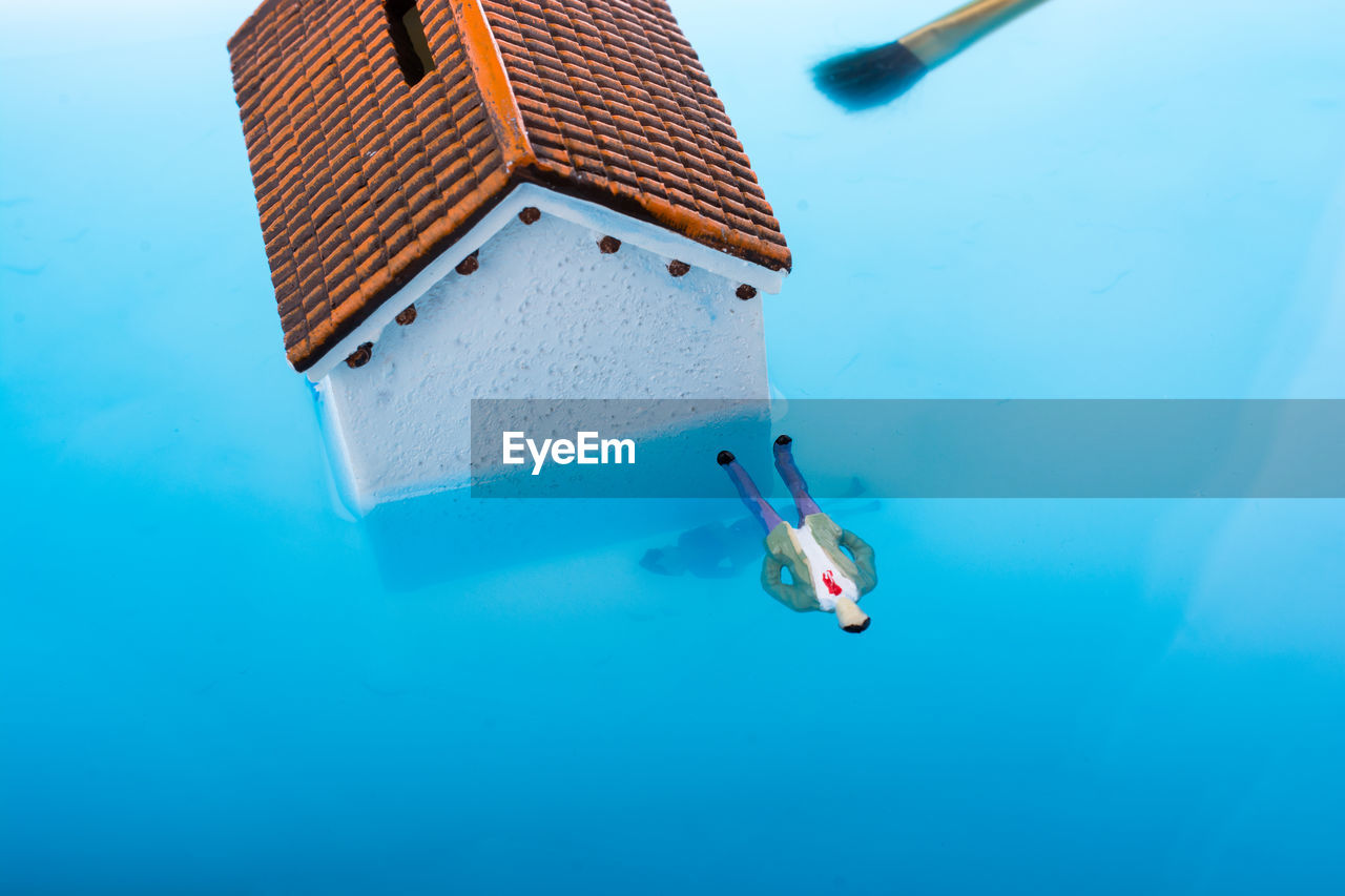 High angle view of figurine with house in water