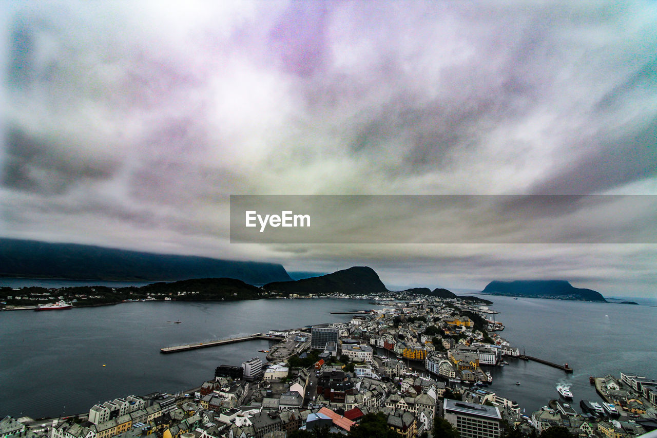 HIGH ANGLE VIEW OF CITY BY SEA AND BUILDINGS AGAINST SKY