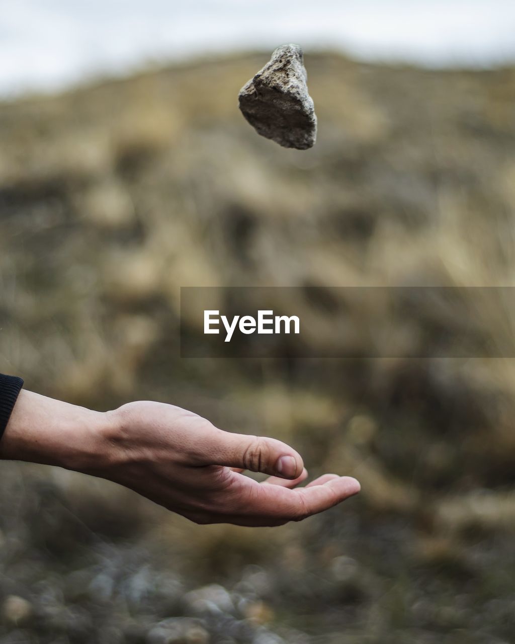 Close-up of hand catching rock