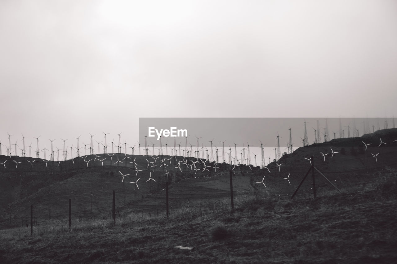 Wind turbines on mountain against sky at mojave desert