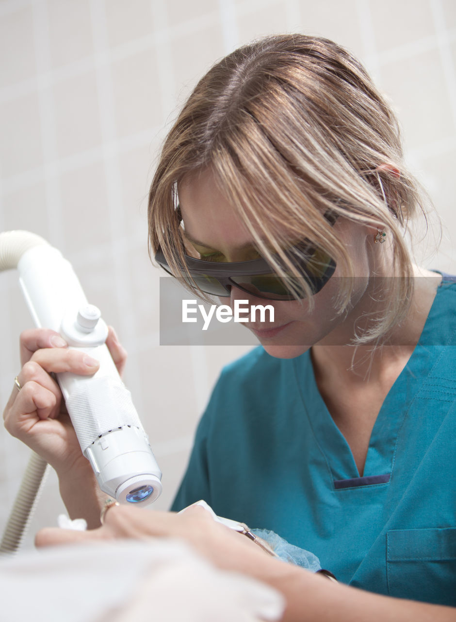 Close-up of woman getting beauty treatment from doctor