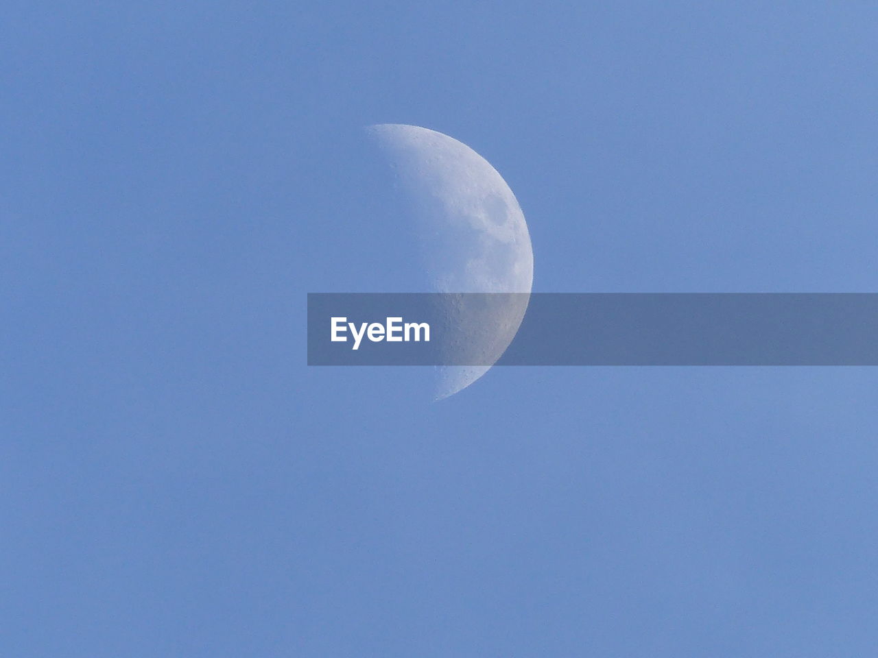 LOW ANGLE VIEW OF HALF MOON IN CLEAR SKY