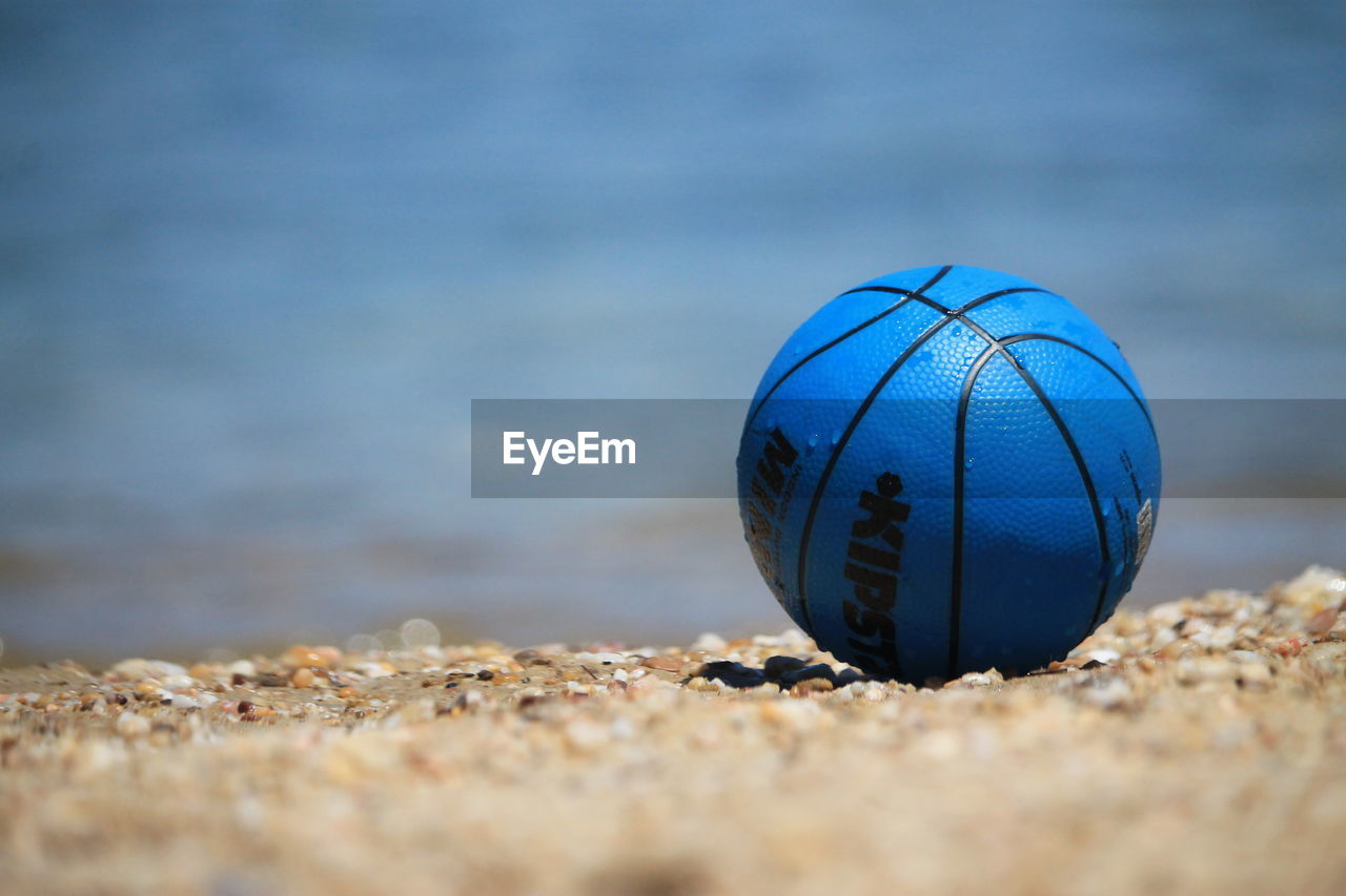 CLOSE-UP OF BALL ON SAND