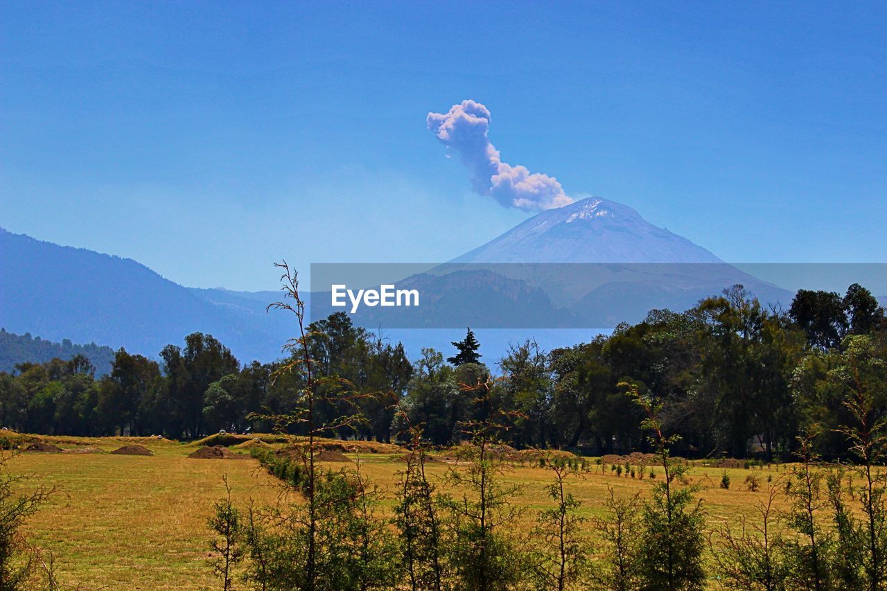 Scenic view of mountain peak against blue sky