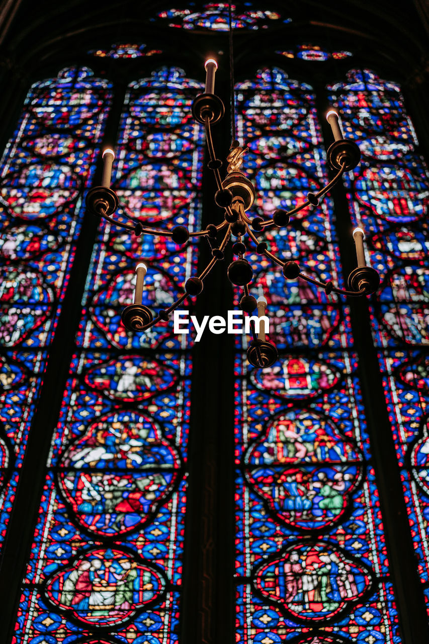 LOW ANGLE VIEW OF ORNATE GLASS WINDOW