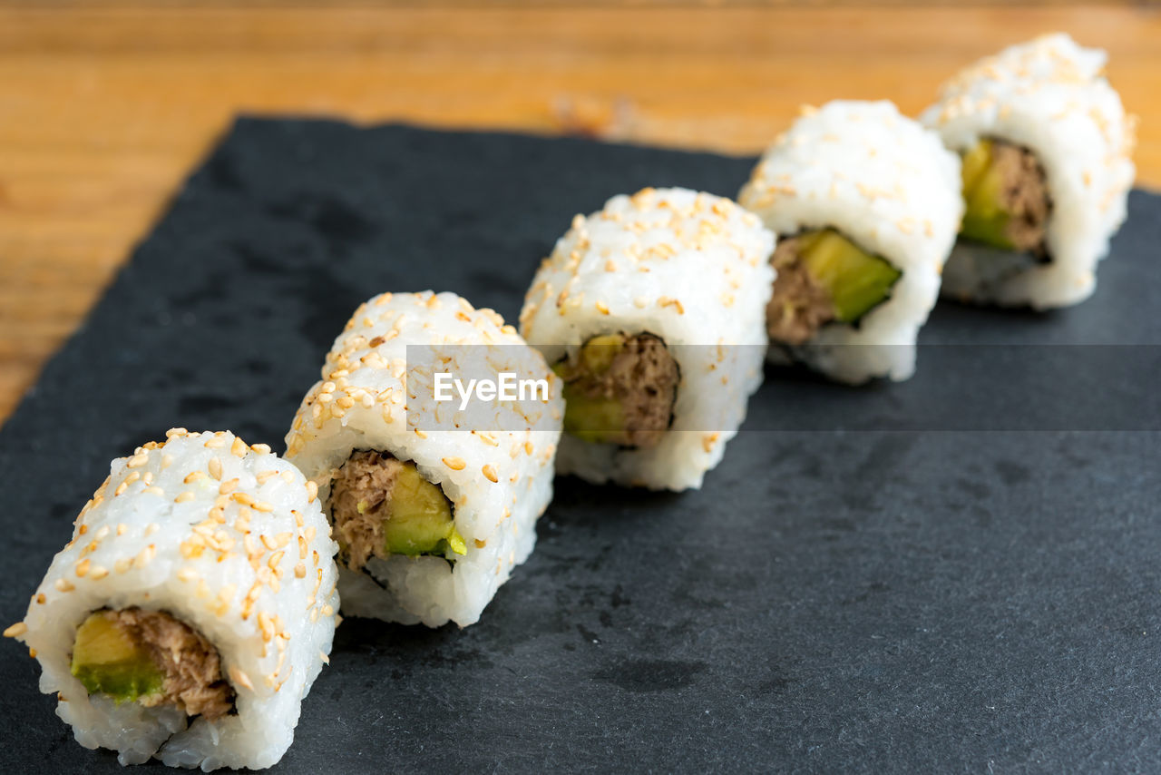 Sushi rolls on granite plate over table