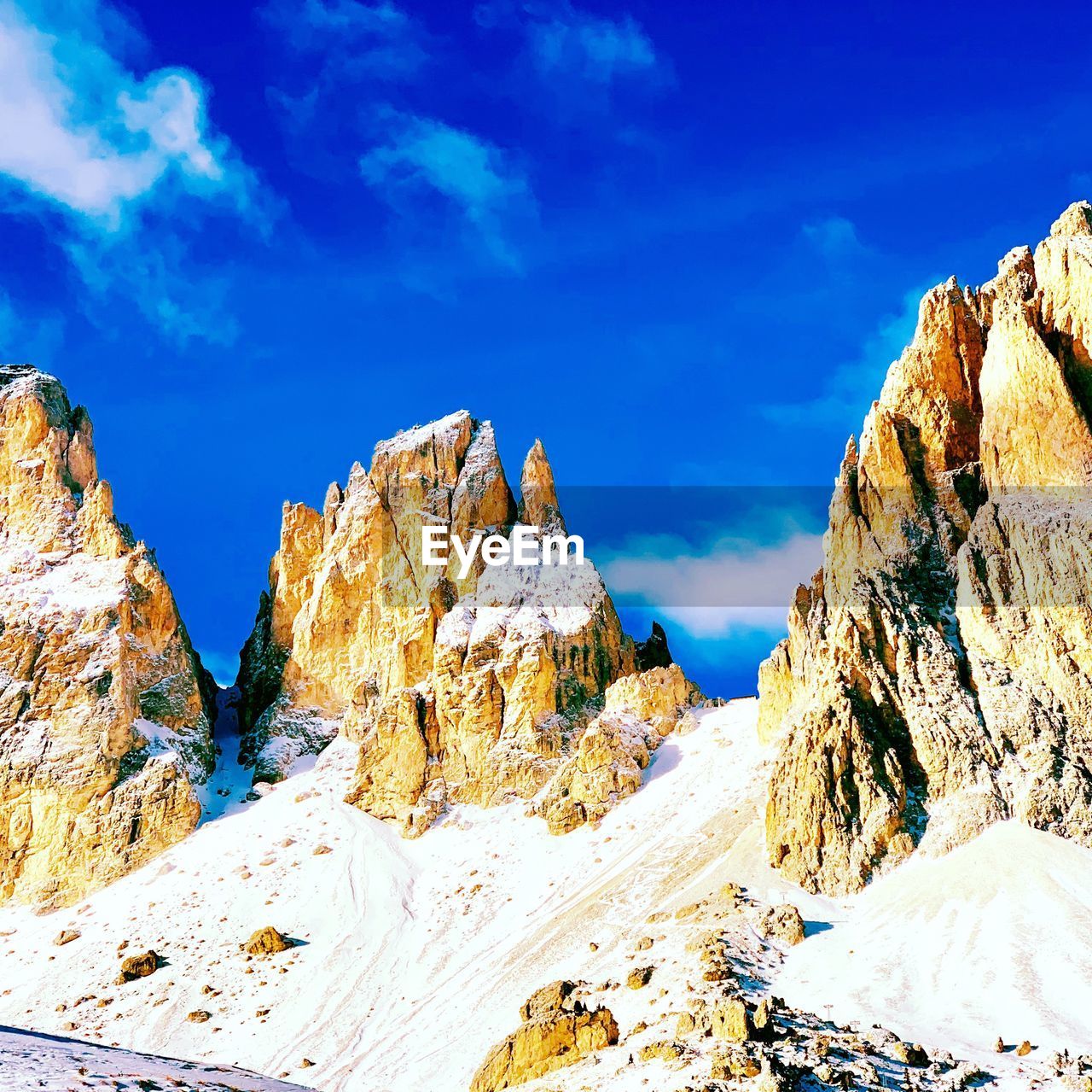 Scenic view of snowcapped mountains against blue sky