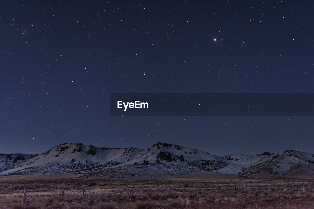 Scenic view of landscape against sky at night