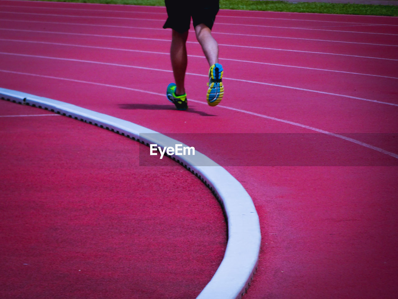 Low section of man running on running track