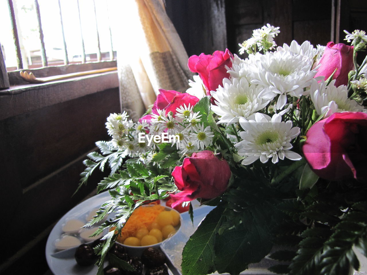 CLOSE-UP OF BOUQUET AGAINST FLOWERS