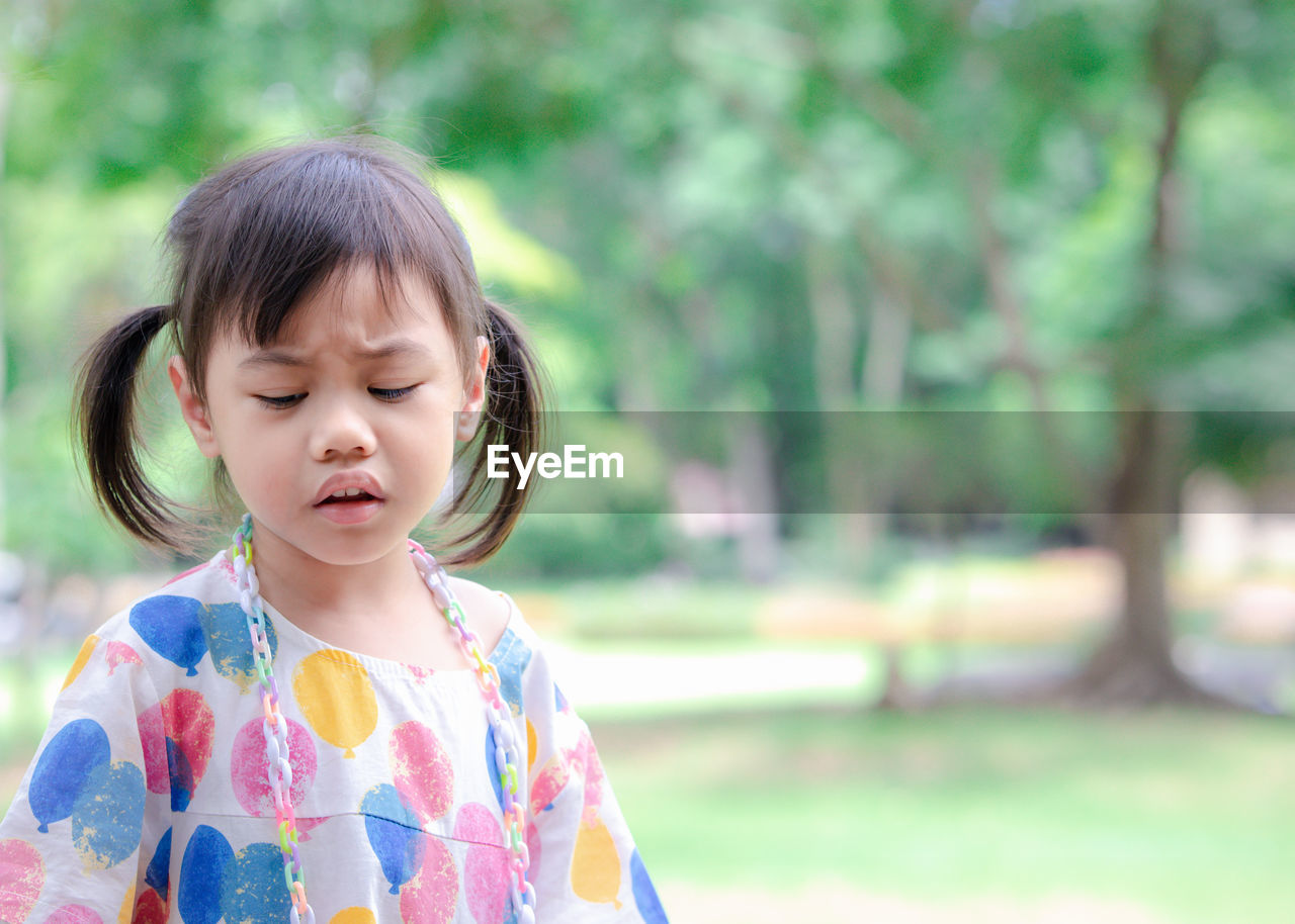 4 years old cute baby asian girl, little toddler child with pigtails hair making frustrated face.