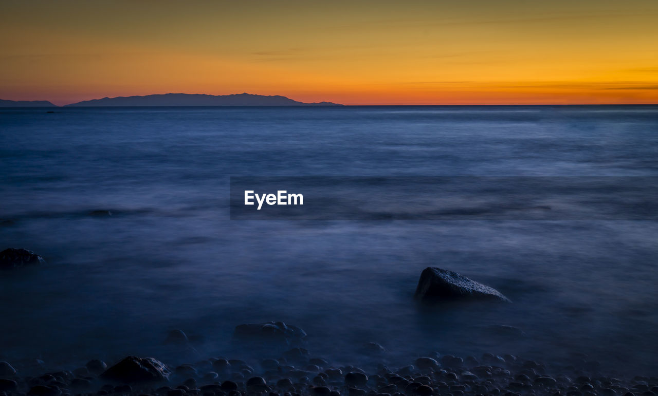 Idyllic shot of sea against sky during sunset