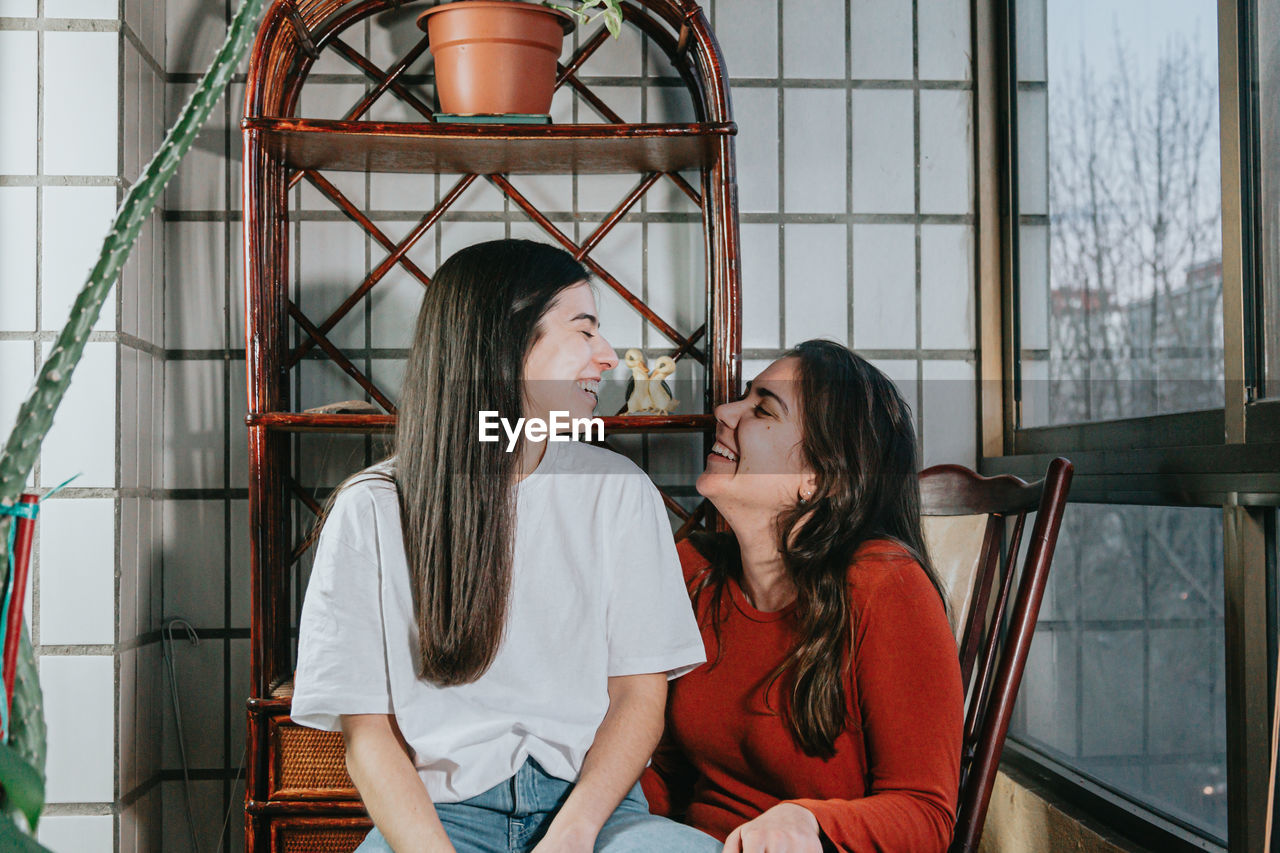 Smiling lesbian women sitting on chair