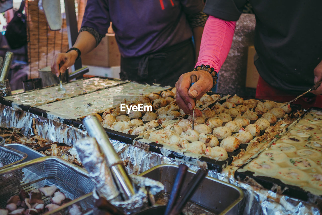 Midsection of man preparing food at market stall