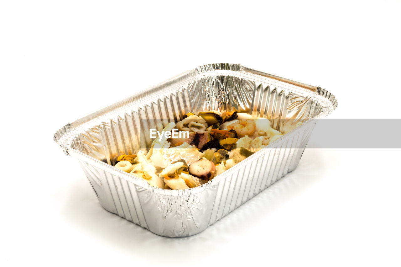 Mix of fish in an aluminum ravier on a white background