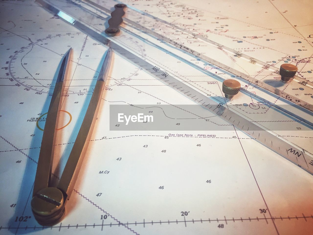 High angle view of drawing compass and ruler on map