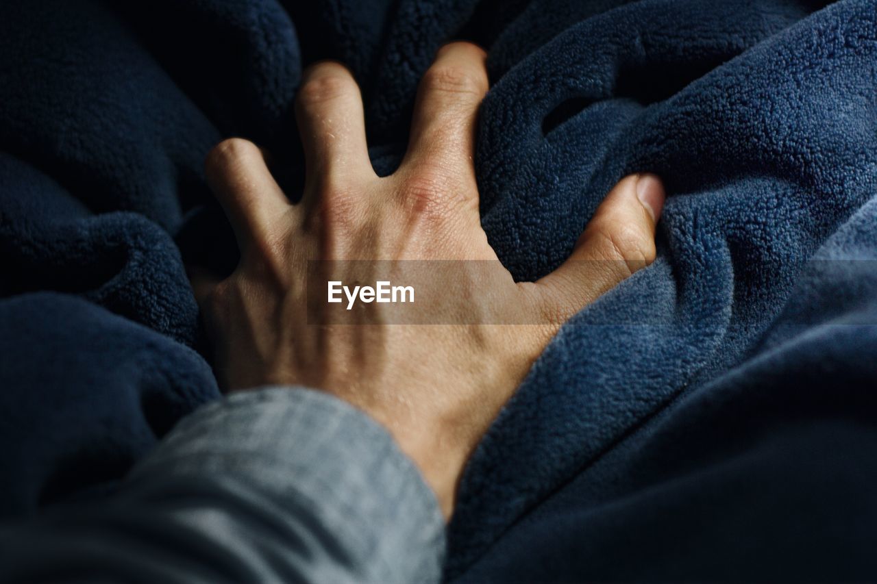 Cropped image of hand on blanket