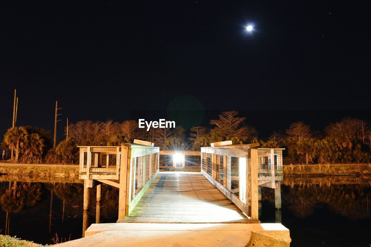 Illuminated scene of wooden bridge at night