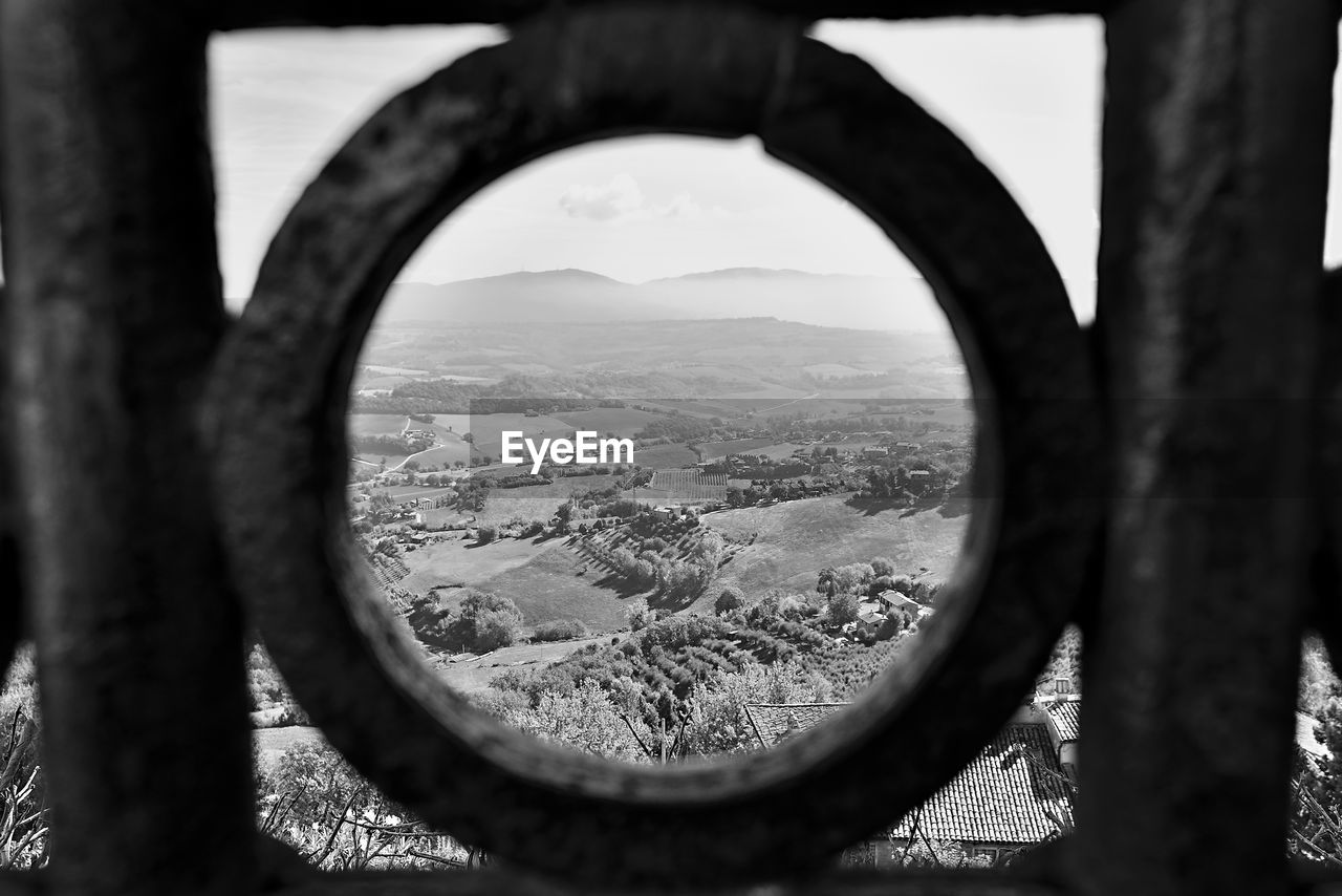 CITYSCAPE SEEN THROUGH HOLE IN WINDOW