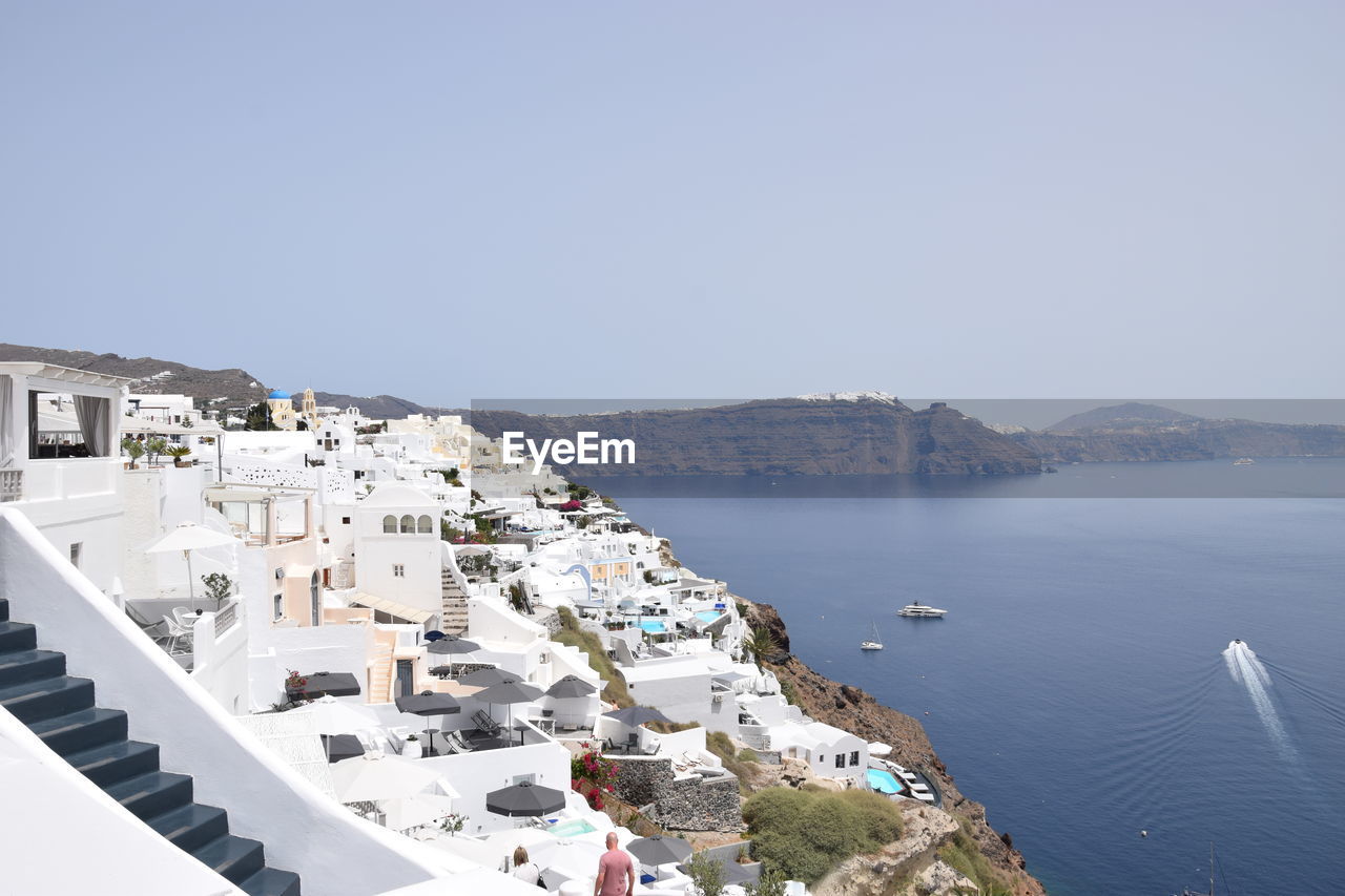 HIGH ANGLE SHOT OF TOWNSCAPE BY SEA AGAINST SKY