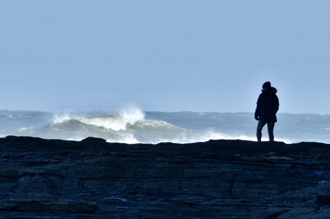 SILHOUETTE MAN STANDING ON BEACH