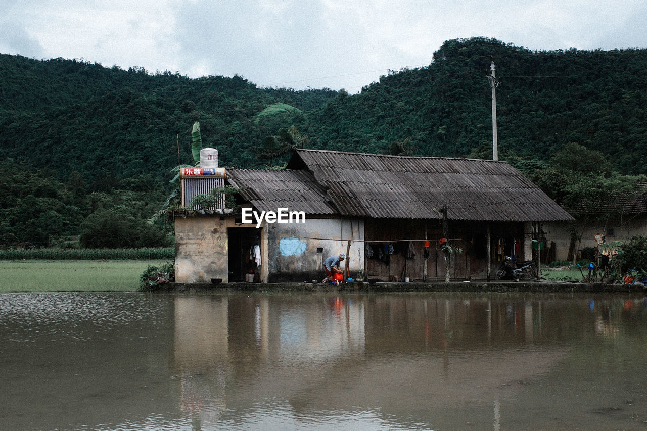 HOUSE BY LAKE AGAINST BUILDING