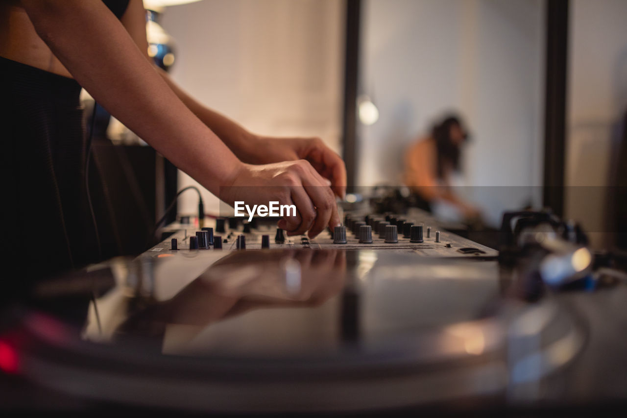 Midsection of woman playing sound mixer at home