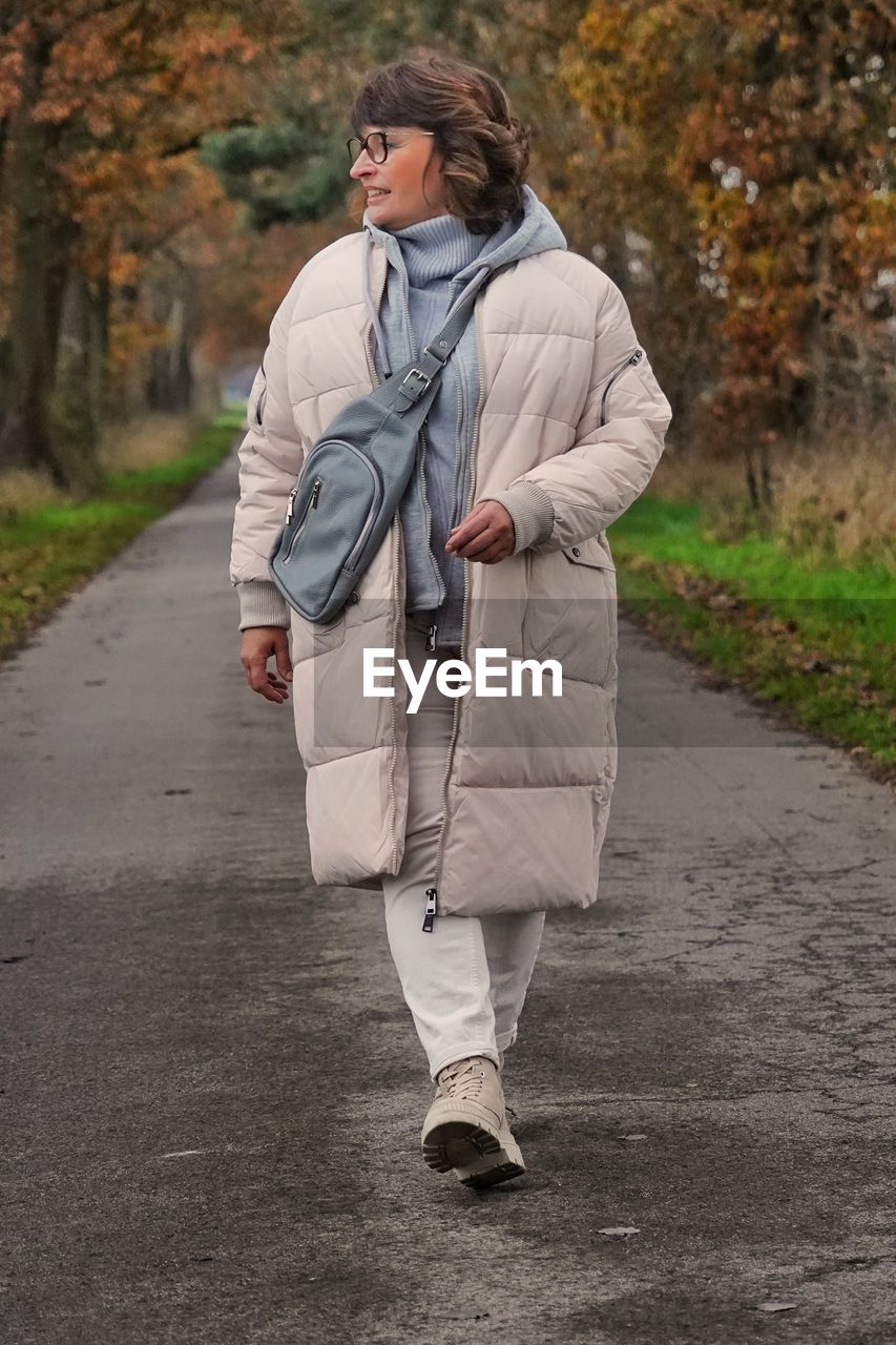 Portrait of young woman walking on road