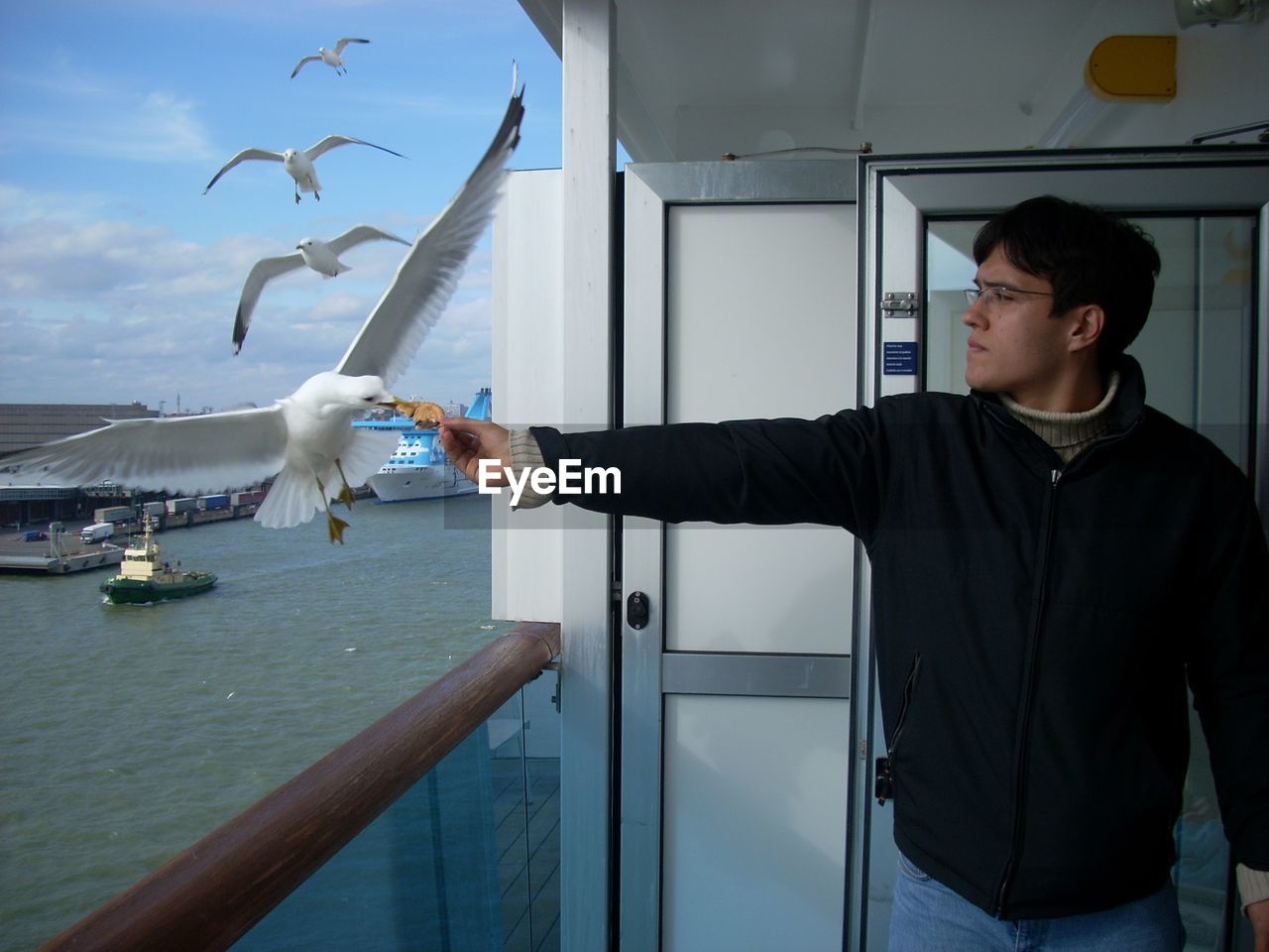 LOW ANGLE VIEW OF MAN STANDING BY FISH