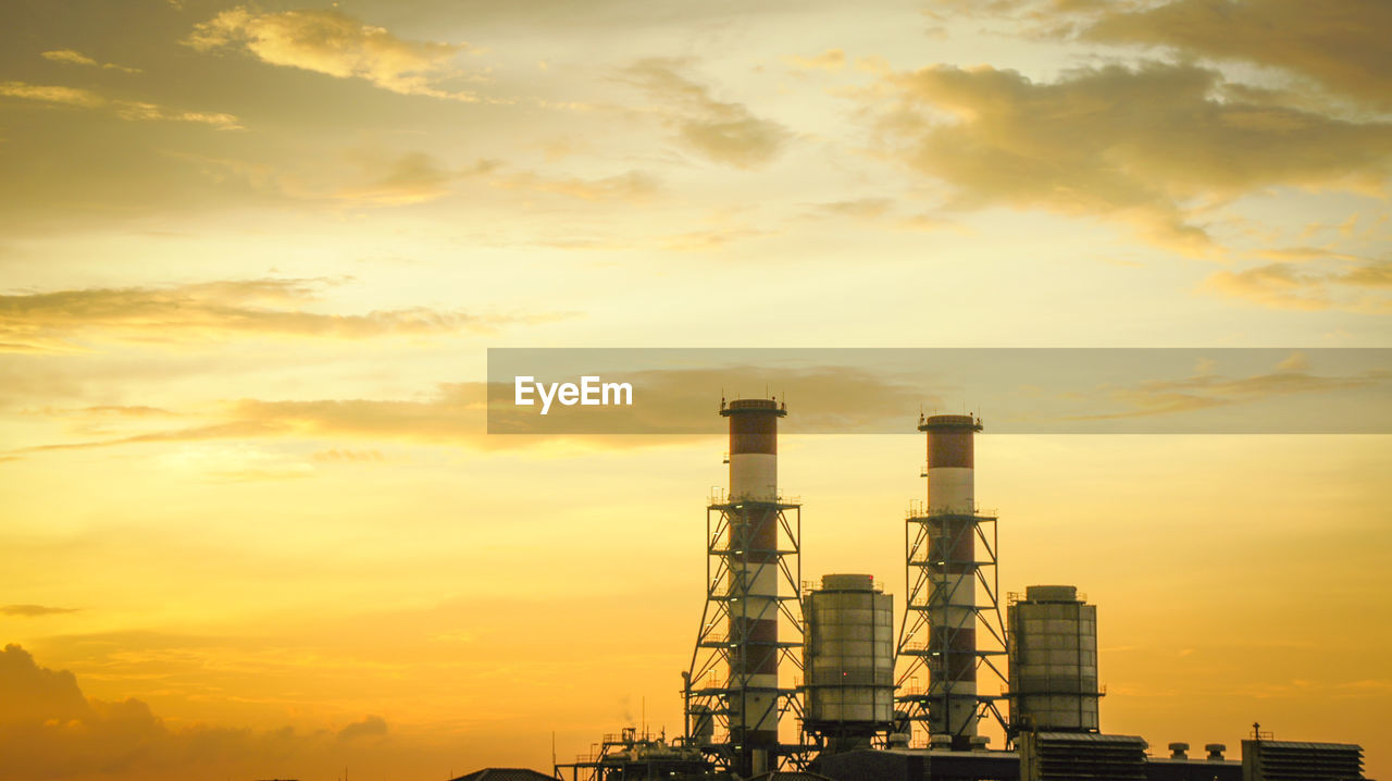 Factory against sky during sunset