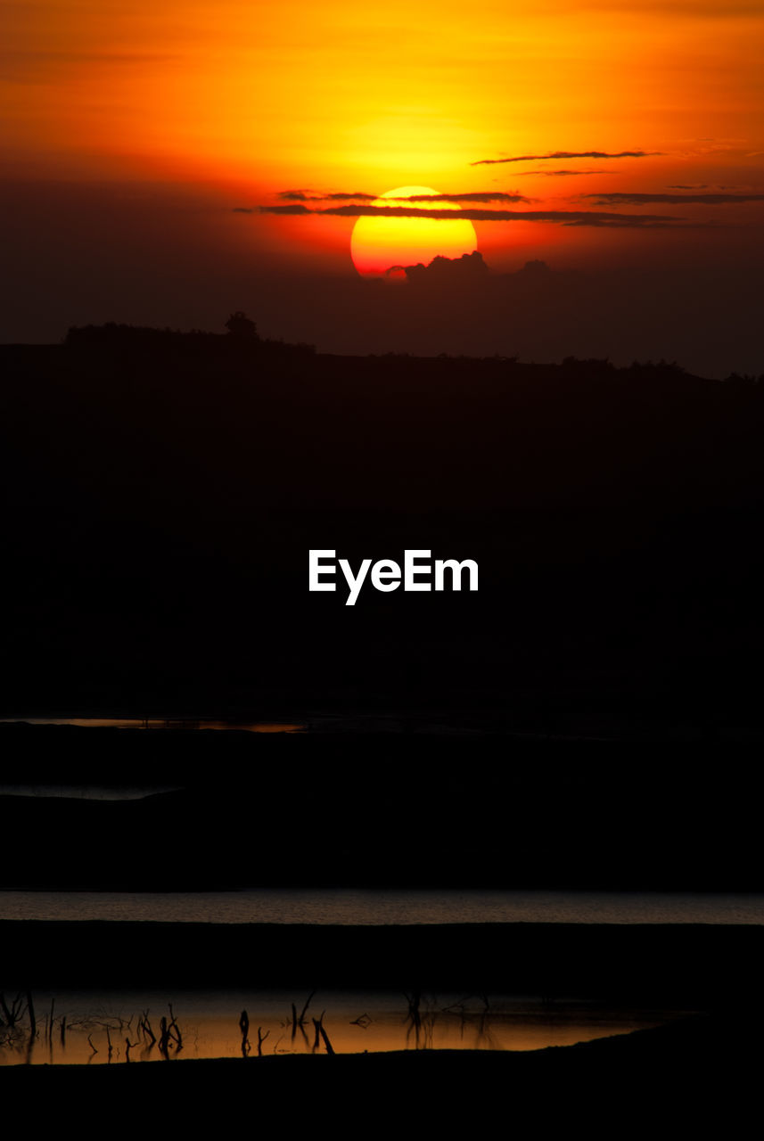 SILHOUETTE LANDSCAPE AGAINST ORANGE SKY