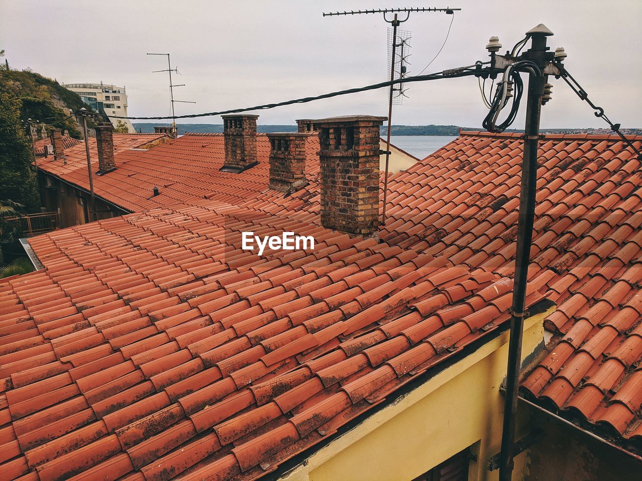 Tilt image of roof and houses against sky in city