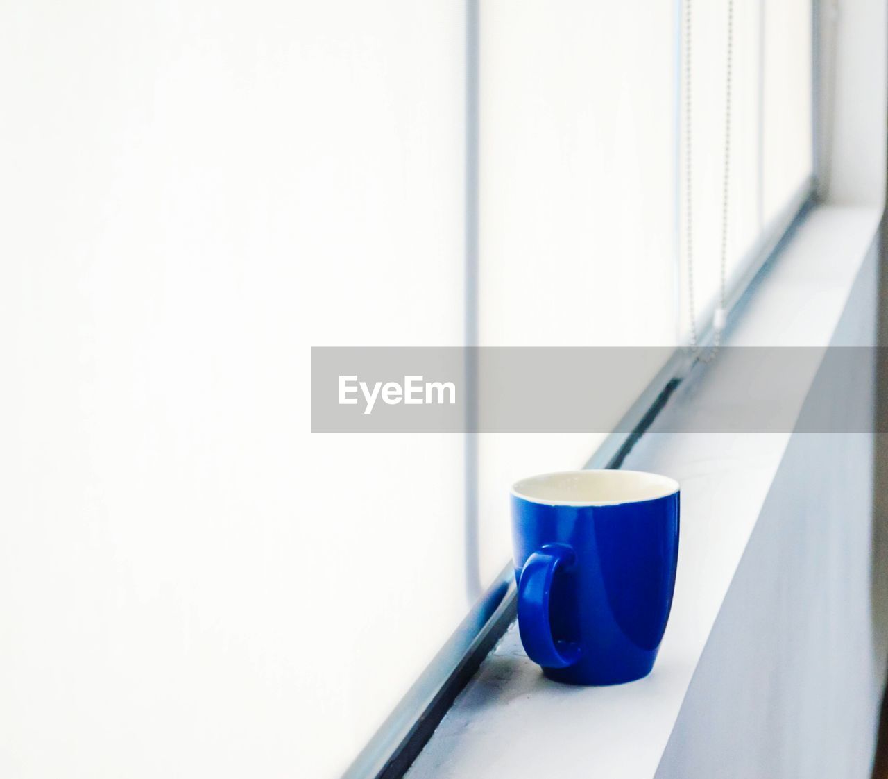 Blue coffee cup on window sill