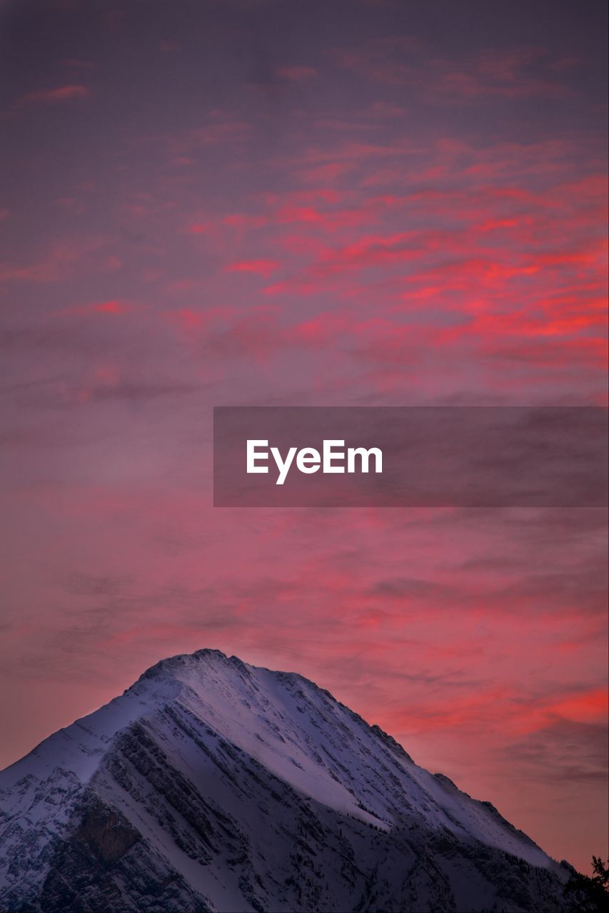 Scenic view of snow covered mountain against sky at sunset