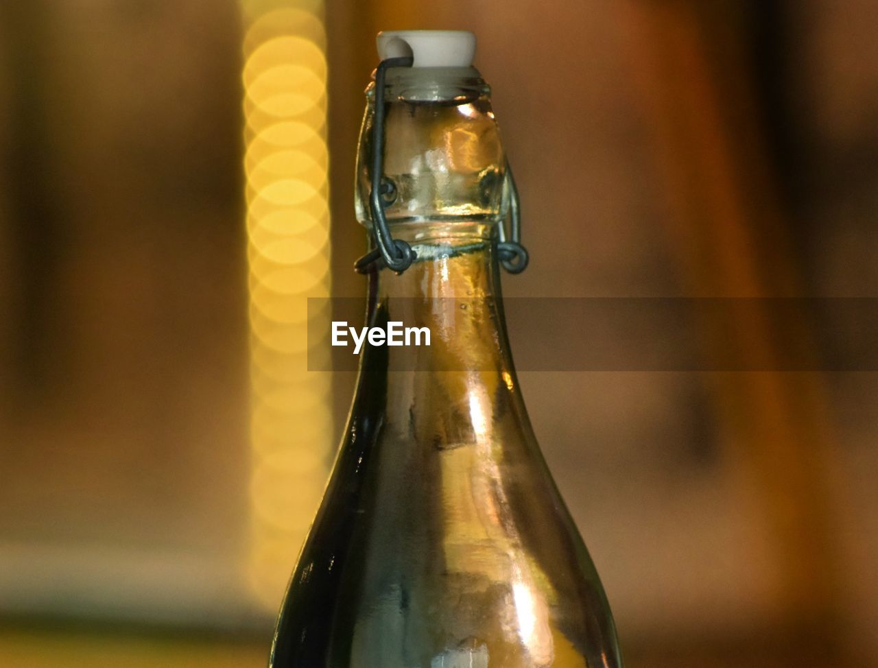 CLOSE-UP OF WINE GLASS WITH BOTTLE ON TABLE