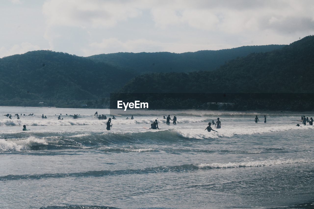 People at beach against sky