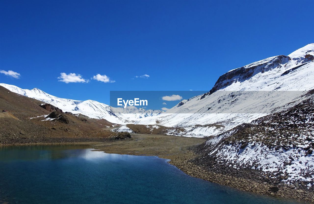 Scenic view of snowcapped mountains against clear blue sky