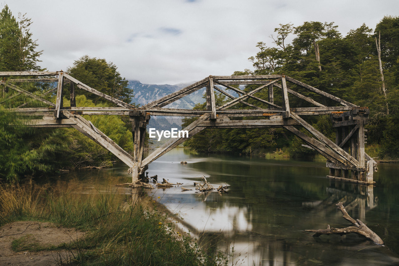 Broken bridge over river in forest