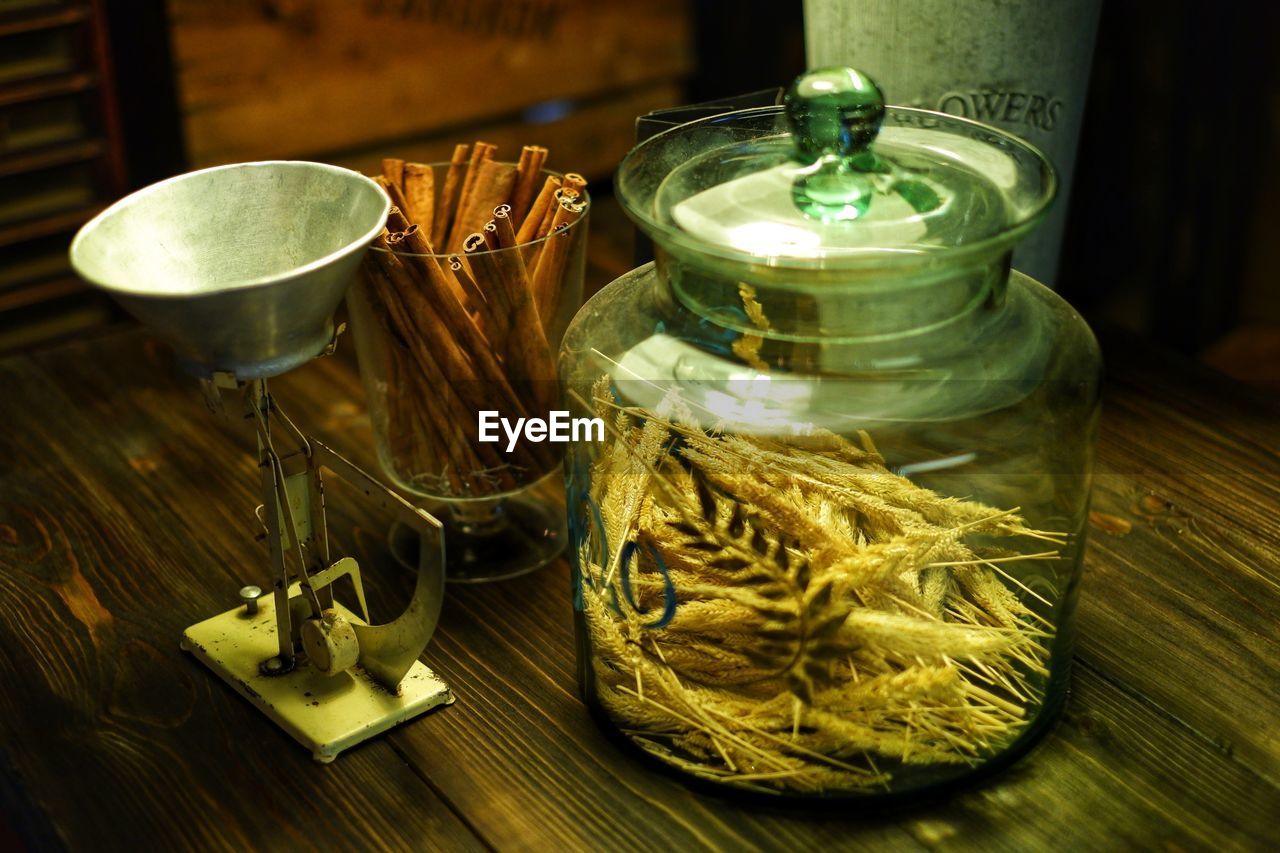 CLOSE-UP OF GLASS OF JAR ON TABLE WITH SPOON