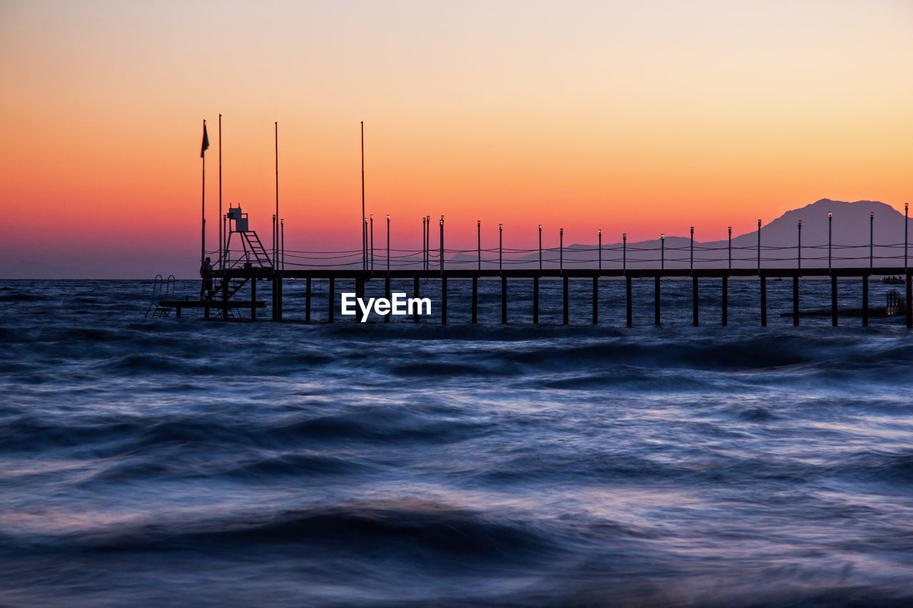 Scenic view of pier against sunset
