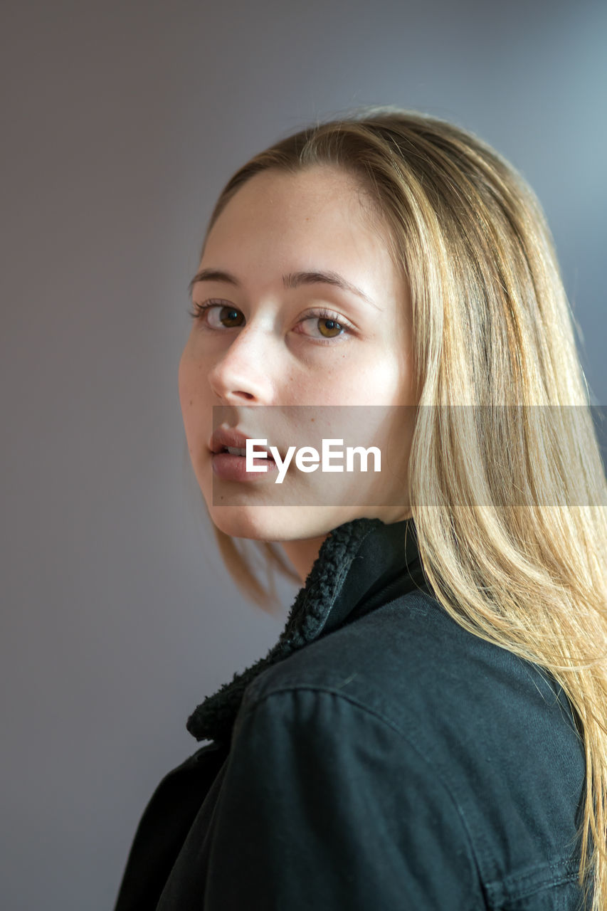 Portrait of a beautiful young woman over grey background