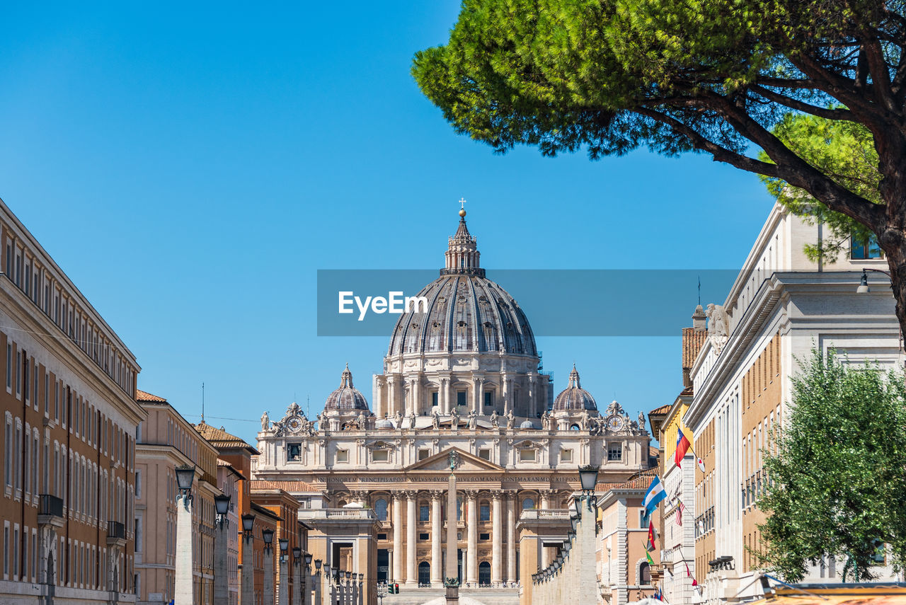 The dome of saint peter  basilica and its statues of saints at st. peter's square, vatican city view