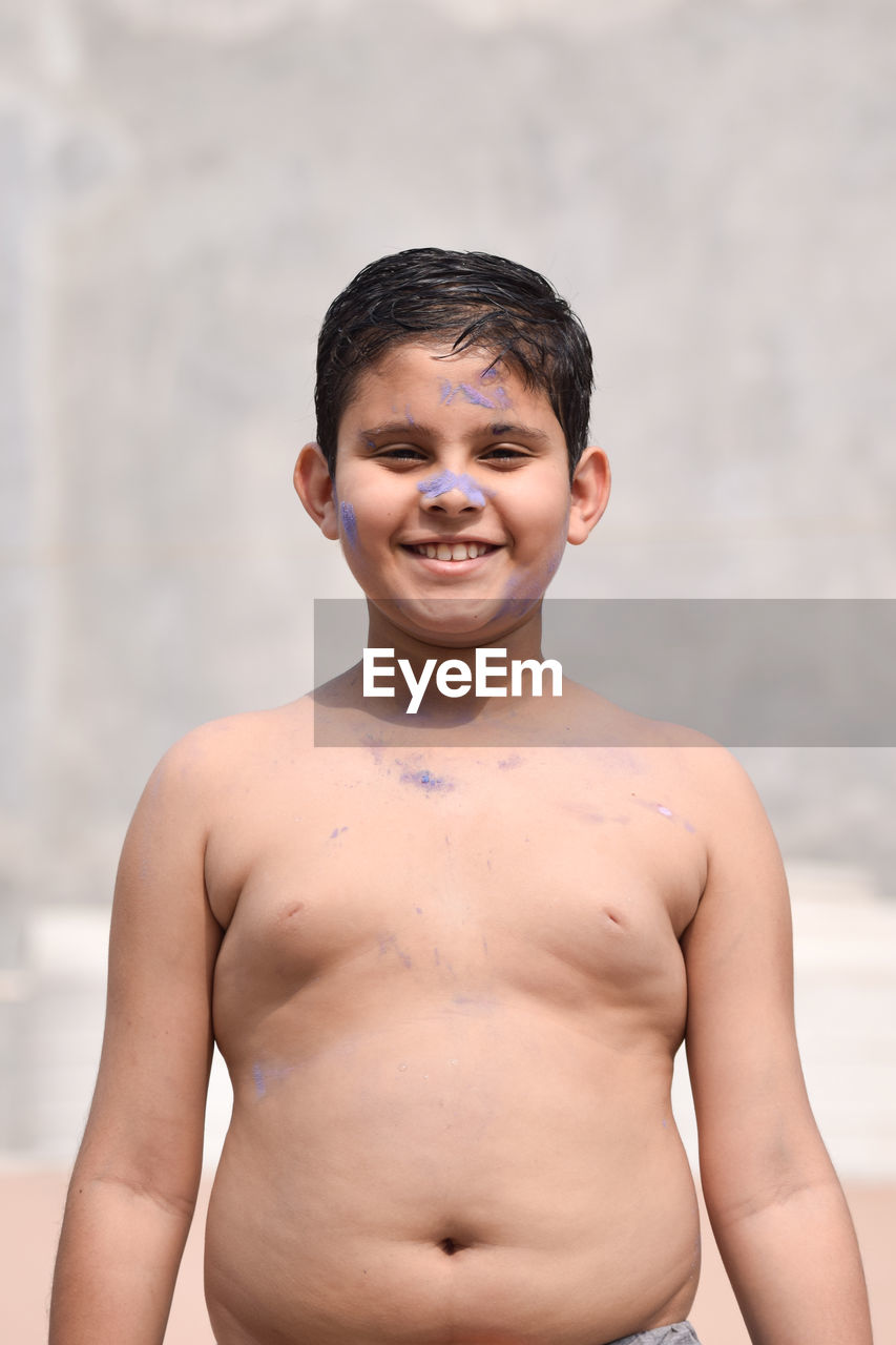 Portrait of smiling shirtless boy standing