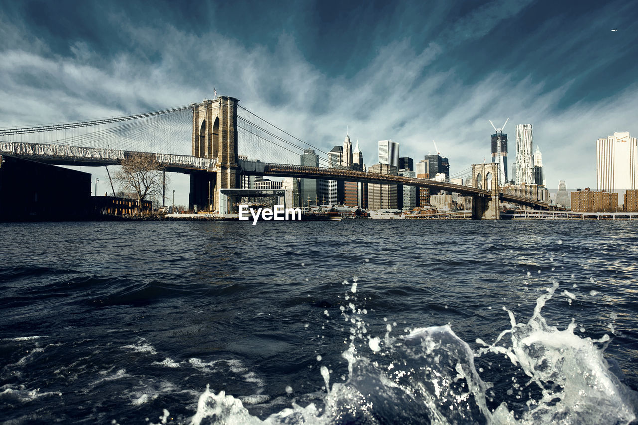 Brooklyn bridge over east river against sky